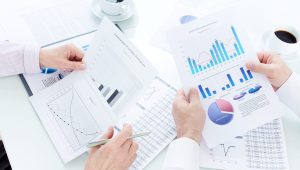 Above angle of mature business partners hands during discussion of papers